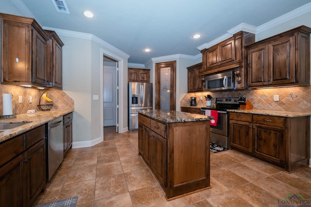 kitchen with dark brown cabinets, stainless steel appliances, crown molding, dark stone countertops, and a kitchen island