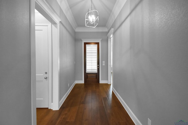 entryway with ornamental molding, dark hardwood / wood-style floors, and a notable chandelier