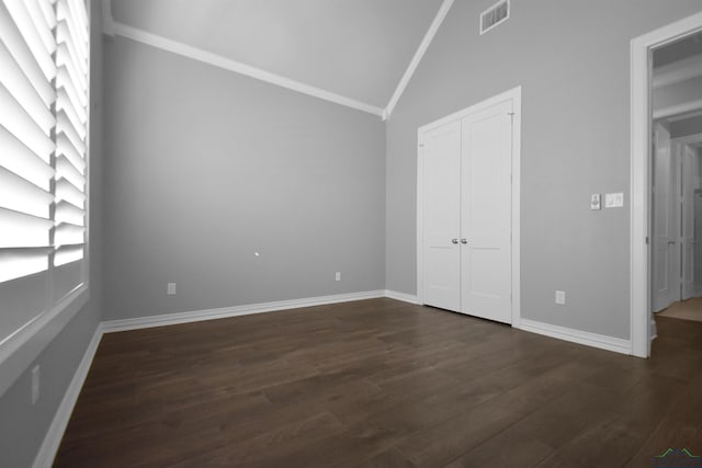 unfurnished bedroom with dark hardwood / wood-style flooring, crown molding, and lofted ceiling