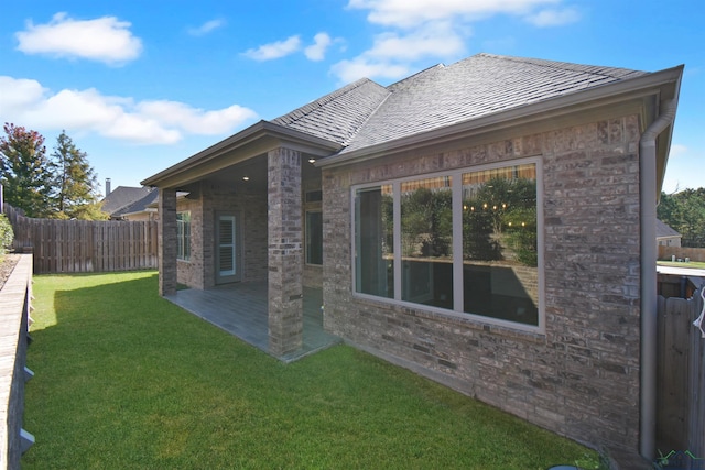 back of property featuring a yard and a patio area