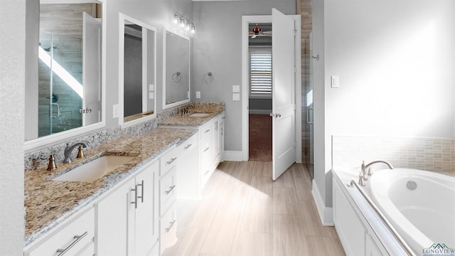 bathroom featuring ceiling fan, vanity, and shower with separate bathtub