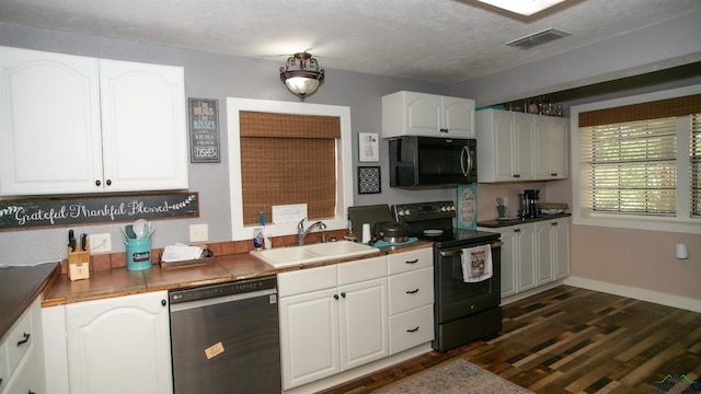 kitchen with a textured ceiling, sink, black appliances, white cabinets, and dark hardwood / wood-style floors