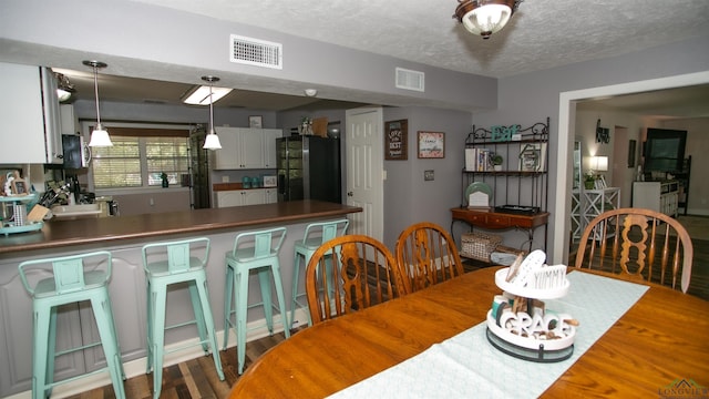 dining room featuring dark hardwood / wood-style flooring and a textured ceiling