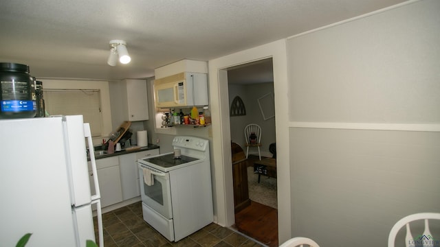 kitchen featuring white cabinetry, white appliances, and a textured ceiling