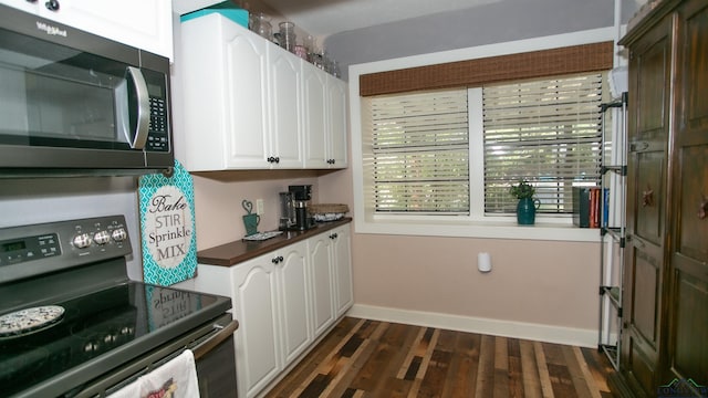 kitchen with dark hardwood / wood-style flooring, white cabinetry, and black range with electric stovetop