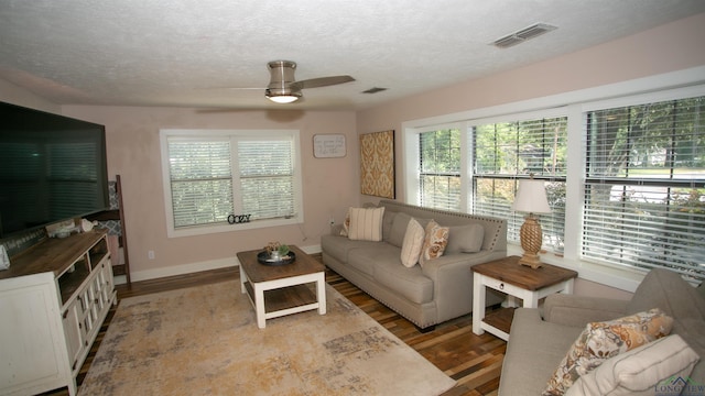 living room featuring a textured ceiling, hardwood / wood-style flooring, and ceiling fan