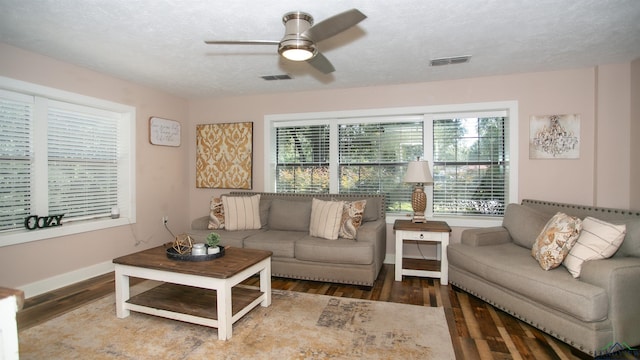 living room featuring ceiling fan, wood-type flooring, and a wealth of natural light