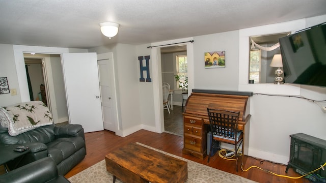 living room featuring dark wood-type flooring and a textured ceiling