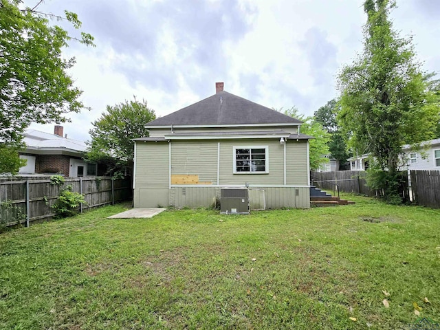605 E Rusk St, Marshall, TX 75670 - rear view of house with central AC, a chimney, and roof with shingles