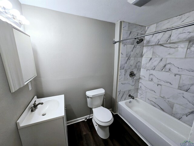 605 E Rusk St, Marshall, TX 75670 - full bathroom featuring wood finished floors, vanity, toilet, bathtub / shower combination, and baseboards