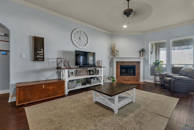 living area with dark wood finished floors, crown molding, and baseboards