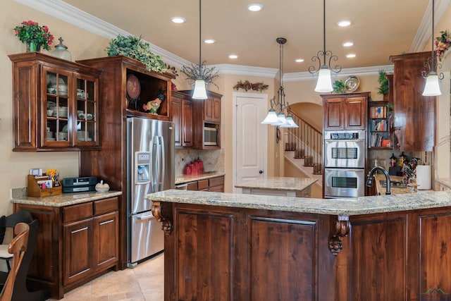 kitchen with pendant lighting, stainless steel appliances, a kitchen island, ornamental molding, and dark brown cabinets