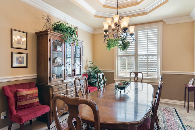 dining room with ornamental molding, an inviting chandelier, and a tray ceiling