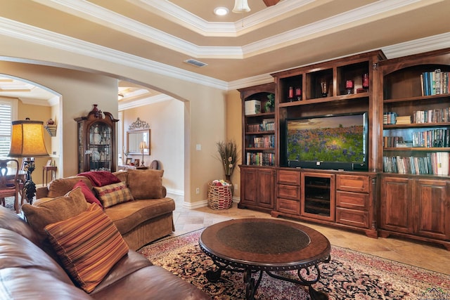 tiled living room with a raised ceiling and ornamental molding