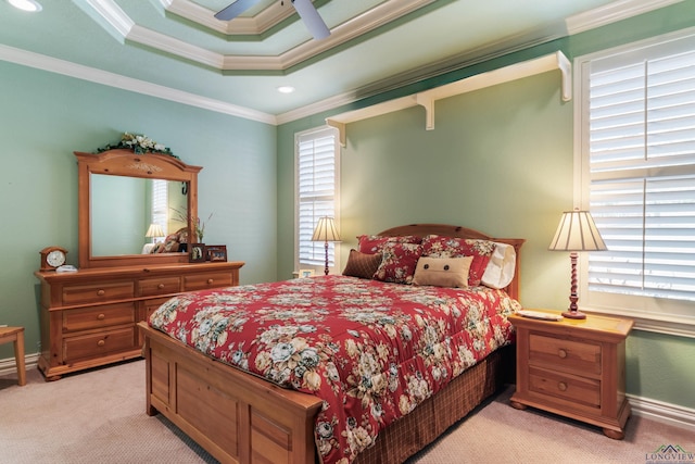 carpeted bedroom with a raised ceiling, ceiling fan, and crown molding