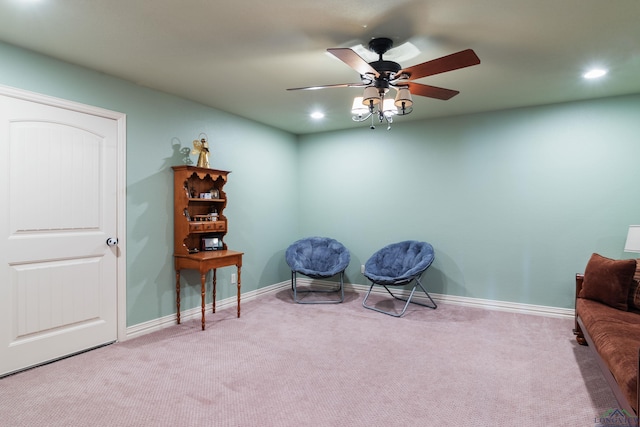 living area with light colored carpet and ceiling fan