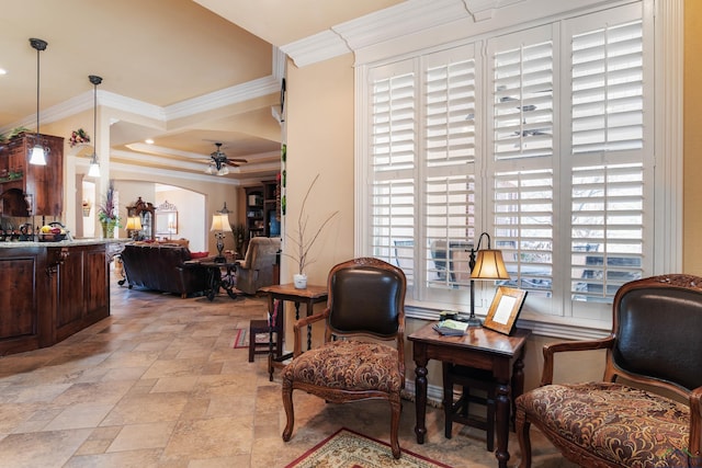 living area featuring ceiling fan and crown molding