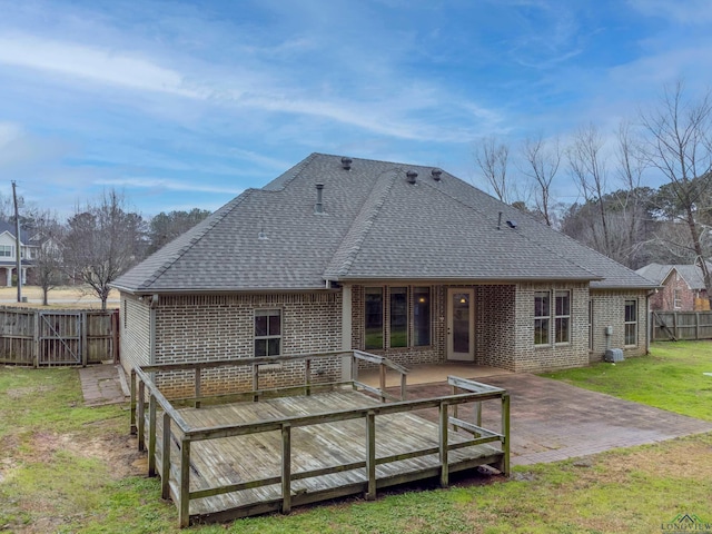 rear view of property featuring a yard, a deck, and a patio