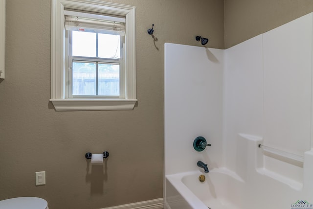 bathroom with toilet and bathing tub / shower combination