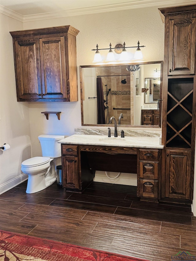 bathroom featuring toilet, vanity, crown molding, and walk in shower