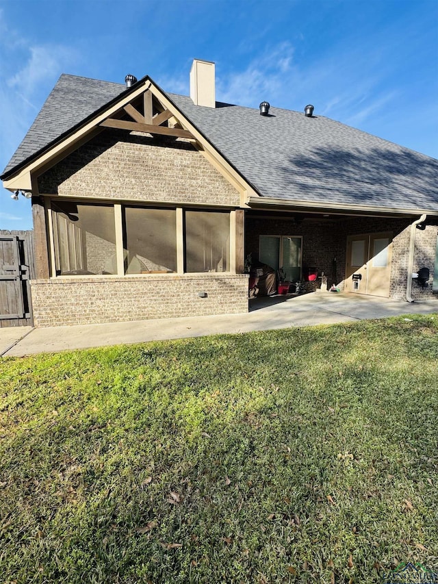 back of property with a yard and a sunroom