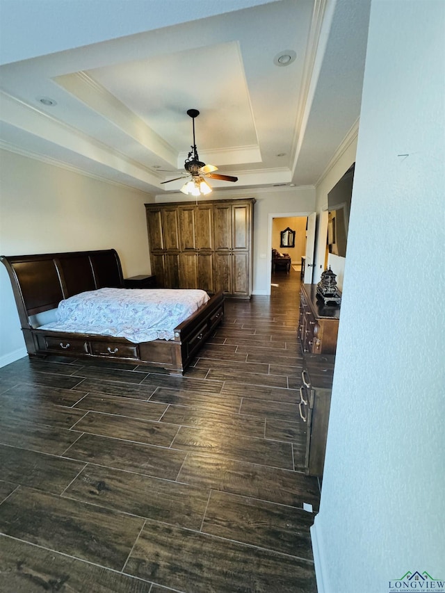 bedroom with ceiling fan, a tray ceiling, and crown molding