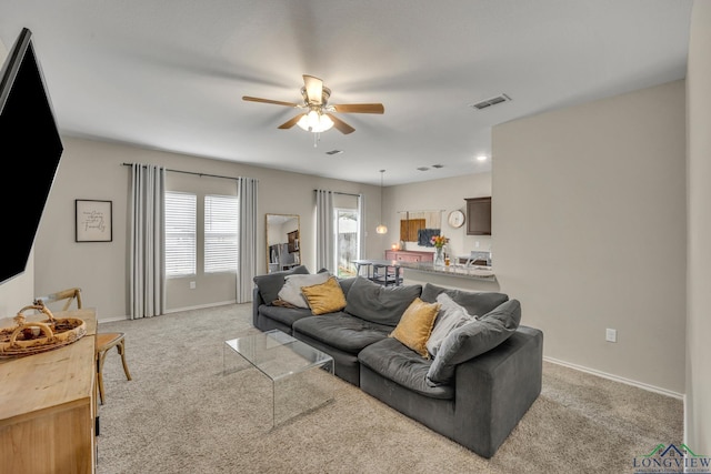 carpeted living room featuring ceiling fan