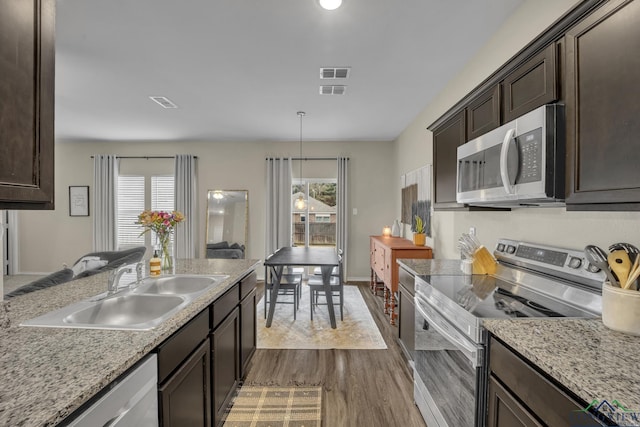 kitchen featuring a healthy amount of sunlight, appliances with stainless steel finishes, decorative light fixtures, and sink