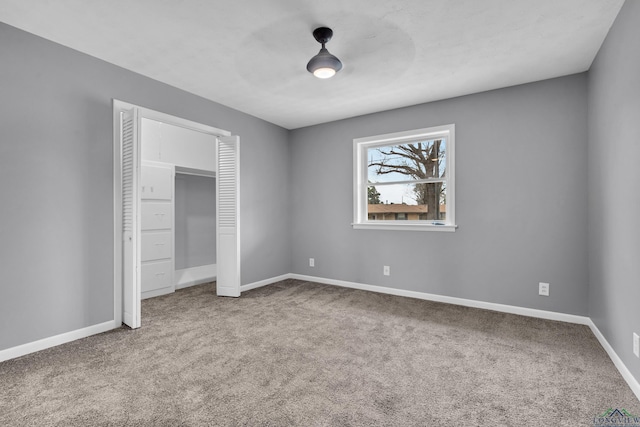 unfurnished bedroom with a closet, baseboards, carpet, and a ceiling fan