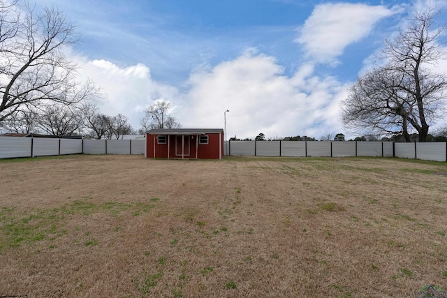 view of yard with a storage shed, an outdoor structure, and fence