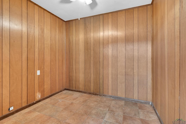 unfurnished room with wood walls and a ceiling fan