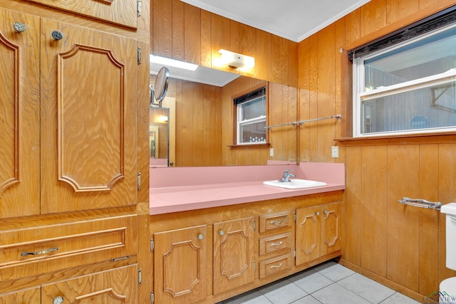 bathroom featuring tile patterned flooring, wood walls, vanity, and ornamental molding