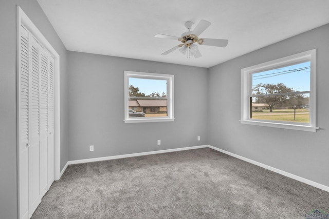 unfurnished bedroom with a closet, baseboards, carpet floors, and ceiling fan