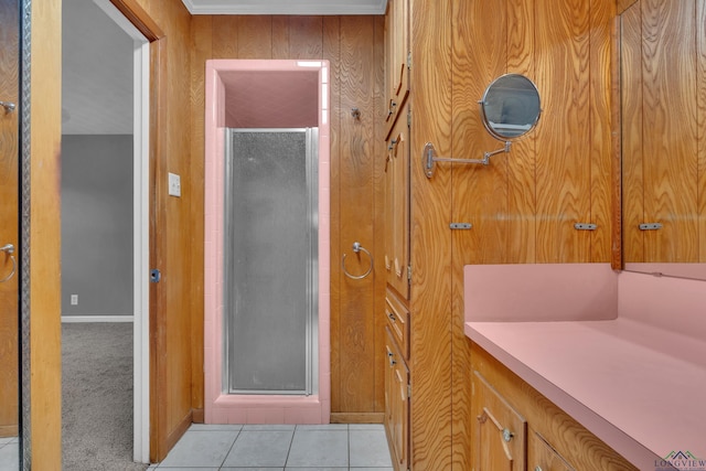 bathroom with tile patterned flooring, a shower stall, and baseboards