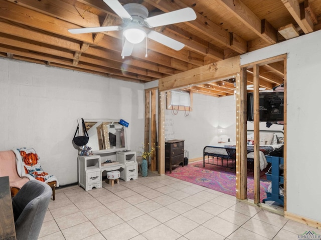 basement featuring light tile patterned floors and ceiling fan