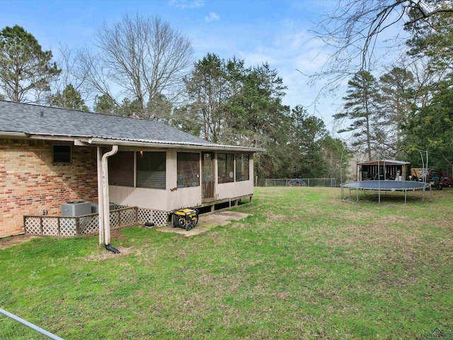 view of yard featuring a sunroom and central air condition unit