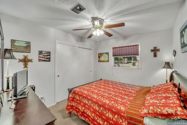 carpeted bedroom featuring ceiling fan, a textured ceiling, and a closet