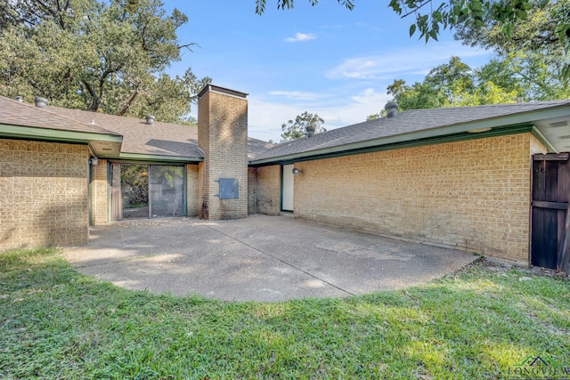 rear view of property featuring a patio and a lawn