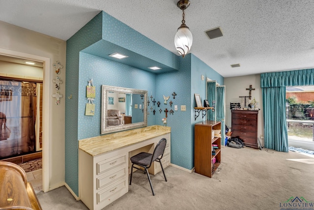 carpeted office space featuring built in desk and a textured ceiling