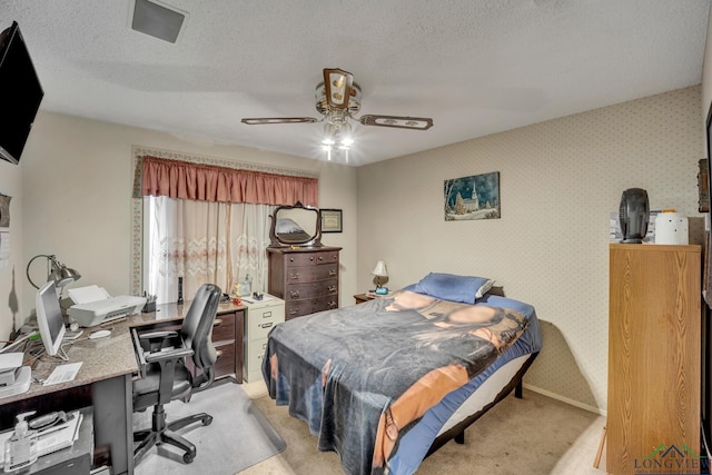 carpeted bedroom featuring ceiling fan and a textured ceiling