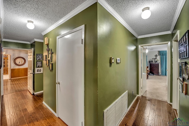 hallway with wood-type flooring and ornamental molding