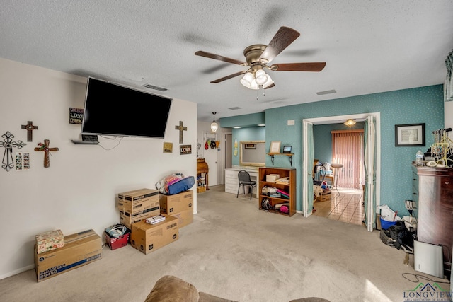 carpeted living room with a textured ceiling and ceiling fan