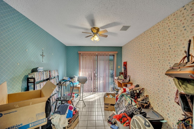 misc room featuring ceiling fan, light tile patterned flooring, and a textured ceiling