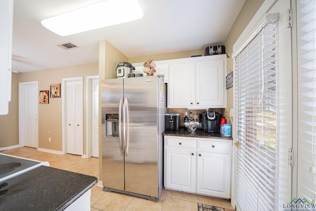 kitchen with light tile patterned floors, stainless steel fridge with ice dispenser, backsplash, white cabinetry, and visible vents