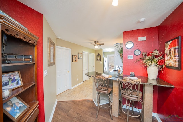 dining space featuring ceiling fan, baseboards, and wood finished floors