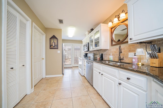 kitchen with a sink, light tile patterned flooring, visible vents, backsplash, and appliances with stainless steel finishes