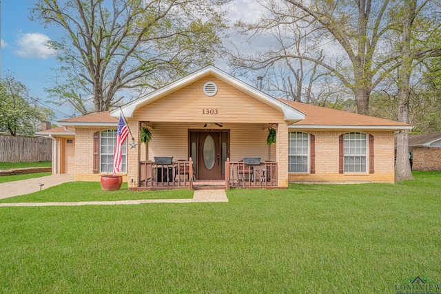 view of front facade featuring brick siding, driveway, a porch, and a front yard