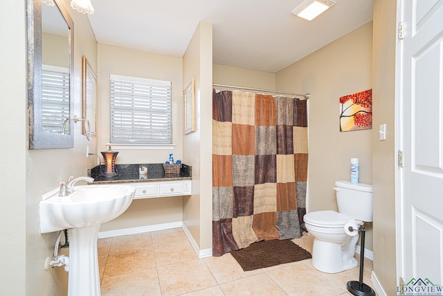 bathroom featuring toilet, tile patterned flooring, a shower with shower curtain, and baseboards
