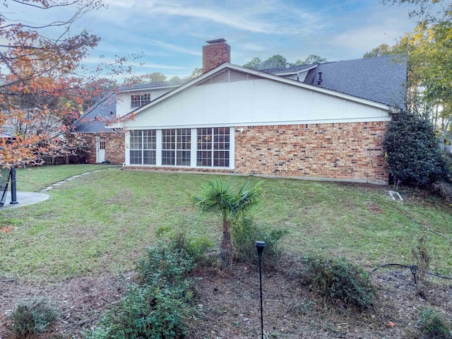 back of house featuring a lawn