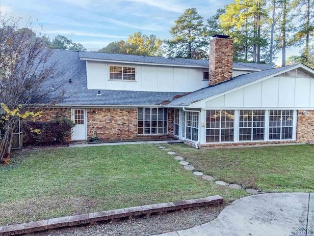 rear view of house with a sunroom and a yard